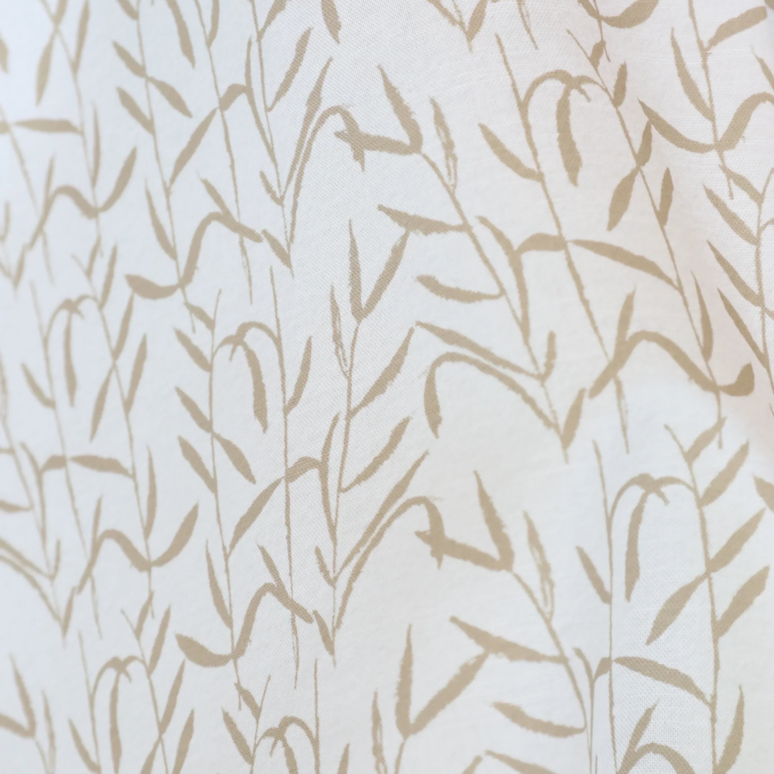 Luxury botanical fabric in warm brass tones with layered painterly organic design, ideal for upholstery, drapery, and sophisticated contemporary interiors.