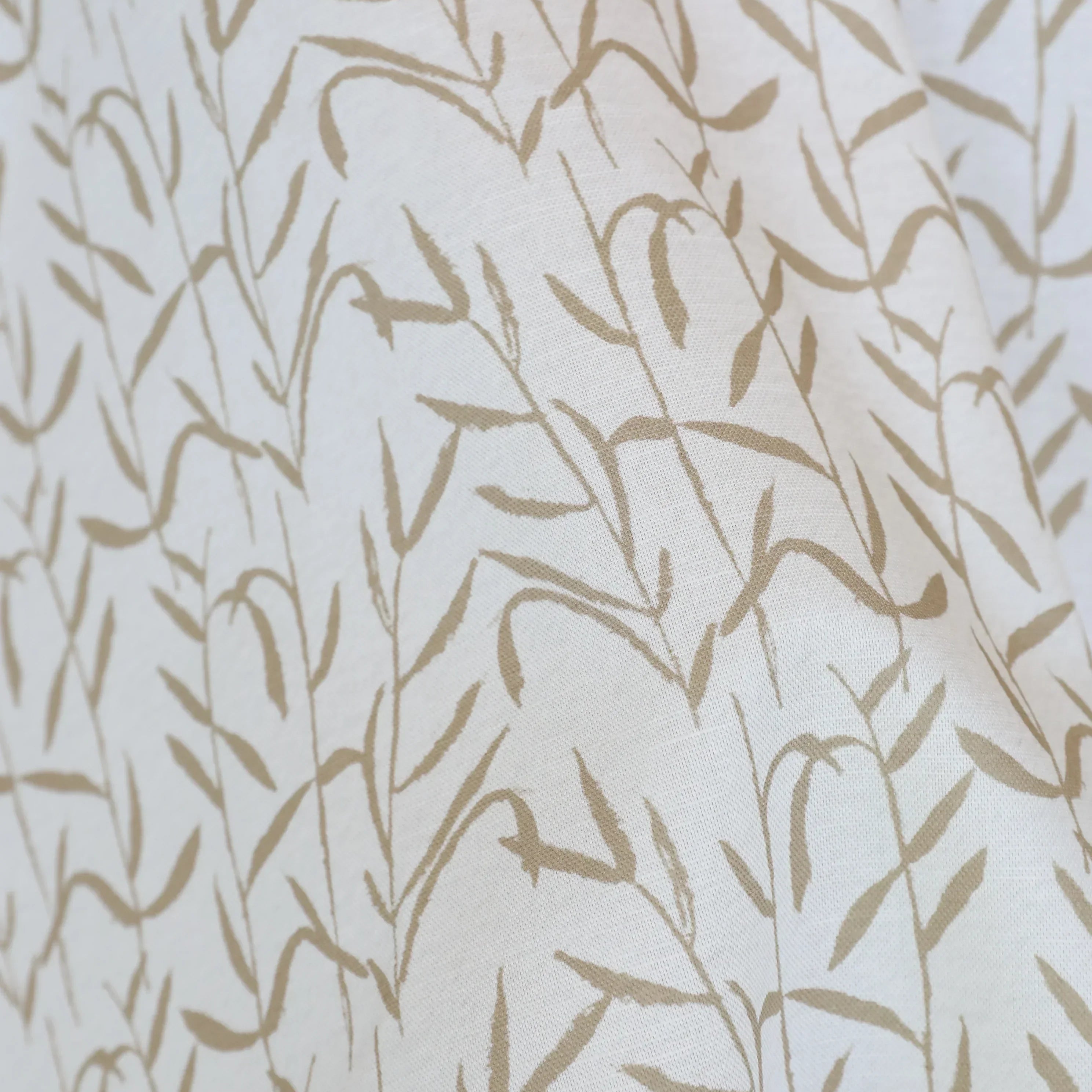 Luxury botanical fabric in warm brass tones with layered painterly organic design, ideal for upholstery, drapery, and sophisticated contemporary interiors.