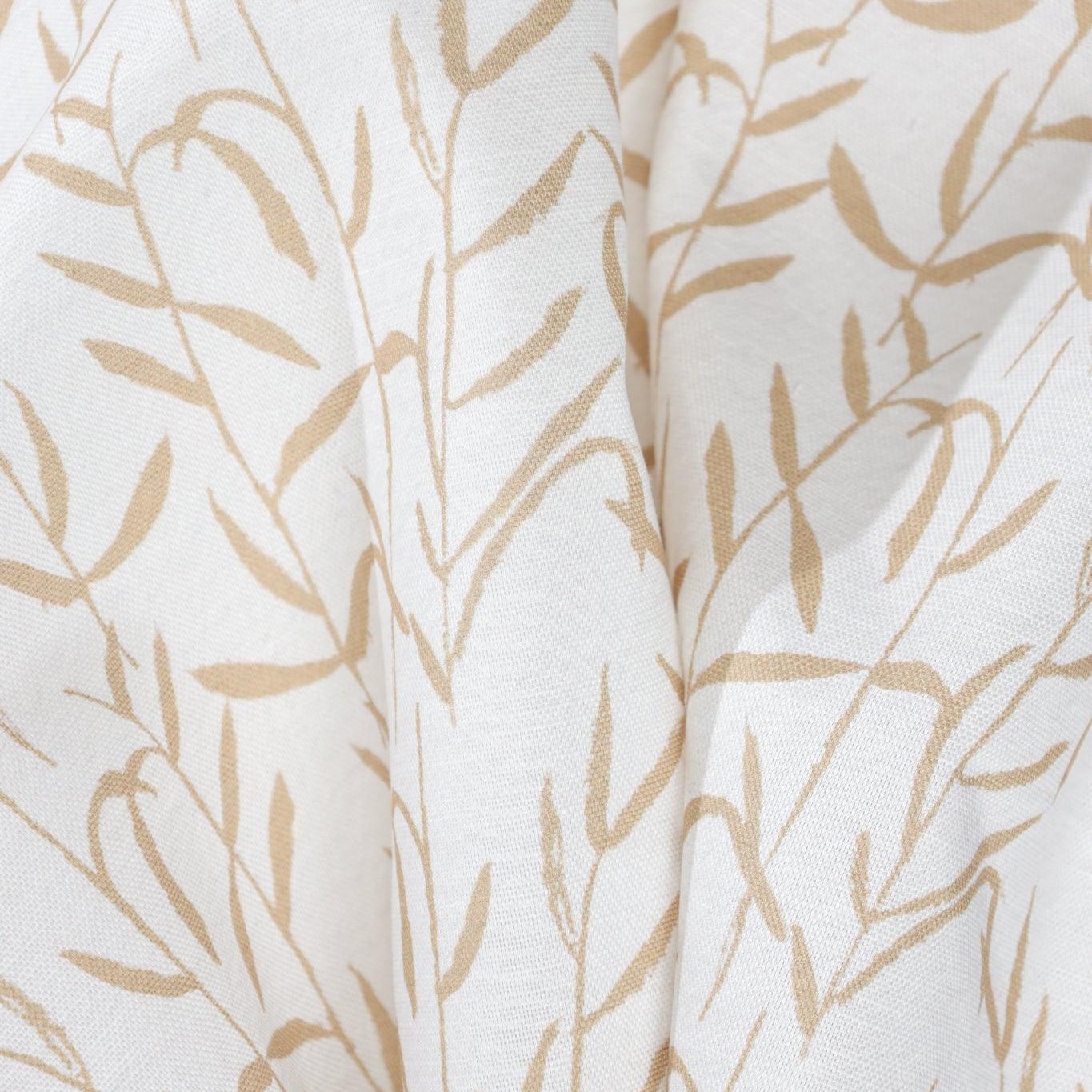 Luxury botanical fabric in warm brass tones with layered painterly organic design, ideal for upholstery, drapery, and sophisticated contemporary interiors.