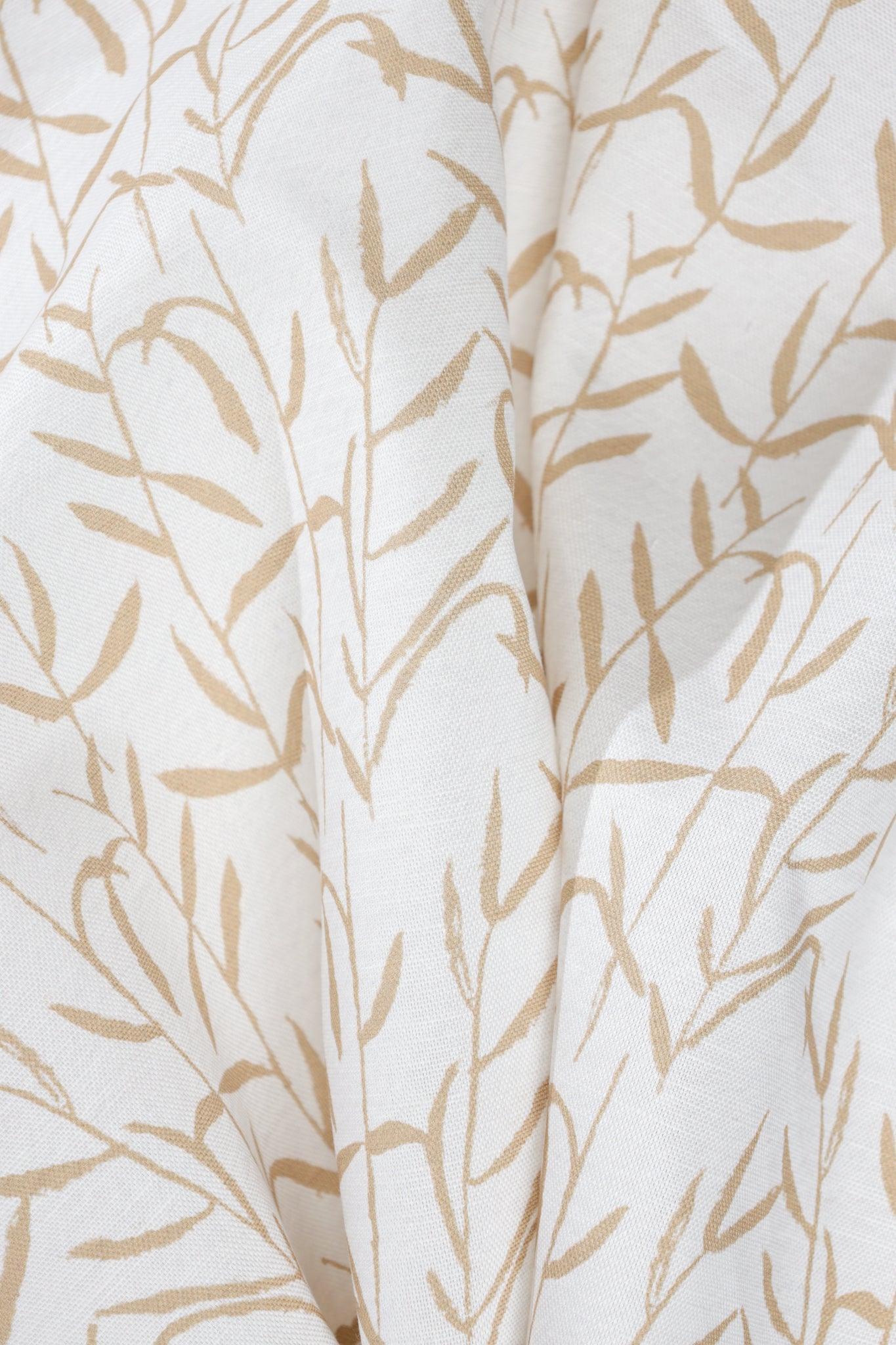 Luxury botanical fabric in warm brass tones with layered painterly organic design, ideal for upholstery, drapery, and sophisticated contemporary interiors.