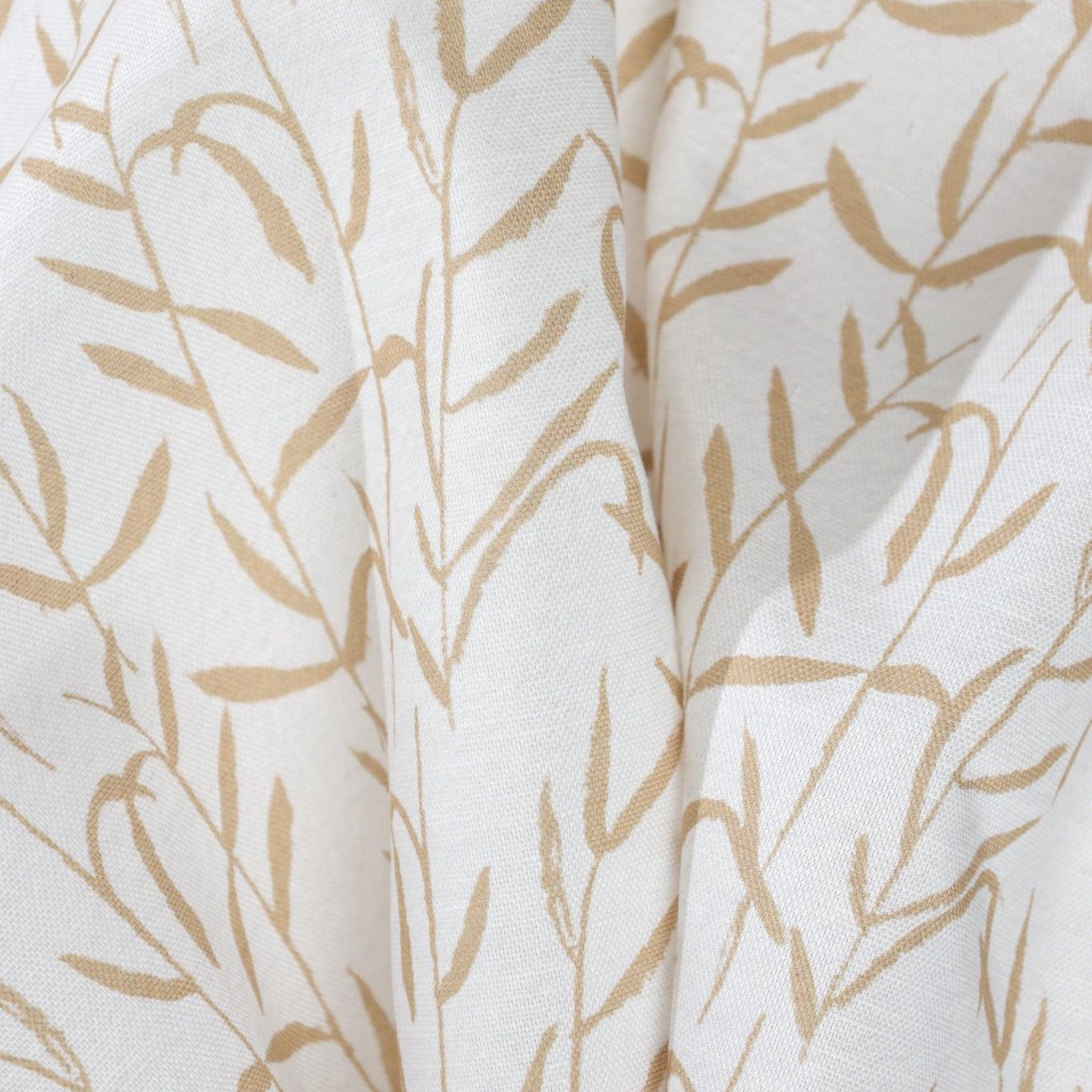 Luxury botanical fabric in warm brass tones with layered painterly organic design, ideal for upholstery, drapery, and sophisticated contemporary interiors.