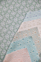 Set of floral fabric swatches in pastel colors on a green background
